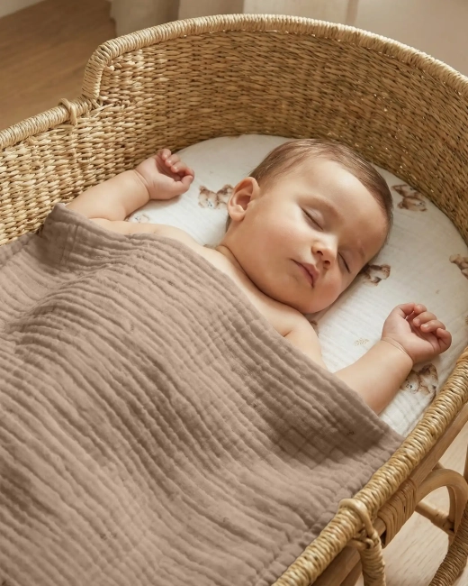 Niemowlę przykryte kocykiem leżące na prześcieradle Albero Mio Vintage Teddy