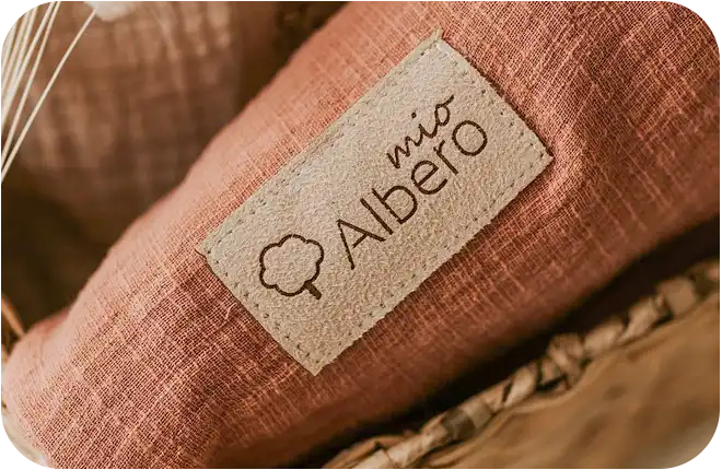 Detal naszywki logo Albero Mio na muślinowym materiale - oferta hurtowa